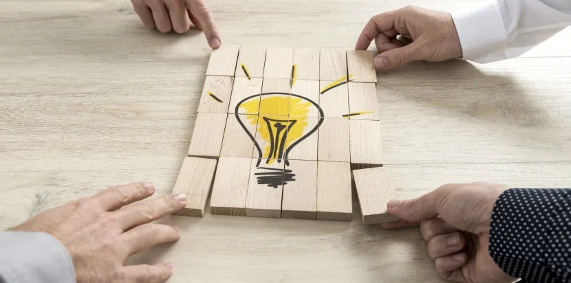 A light bulb made of puzzle pieces representing teamwork, creativity, and aligning company values in corporate team building