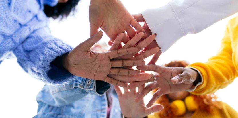 Team members stacking hands during a communication-based team building session in Malaysia