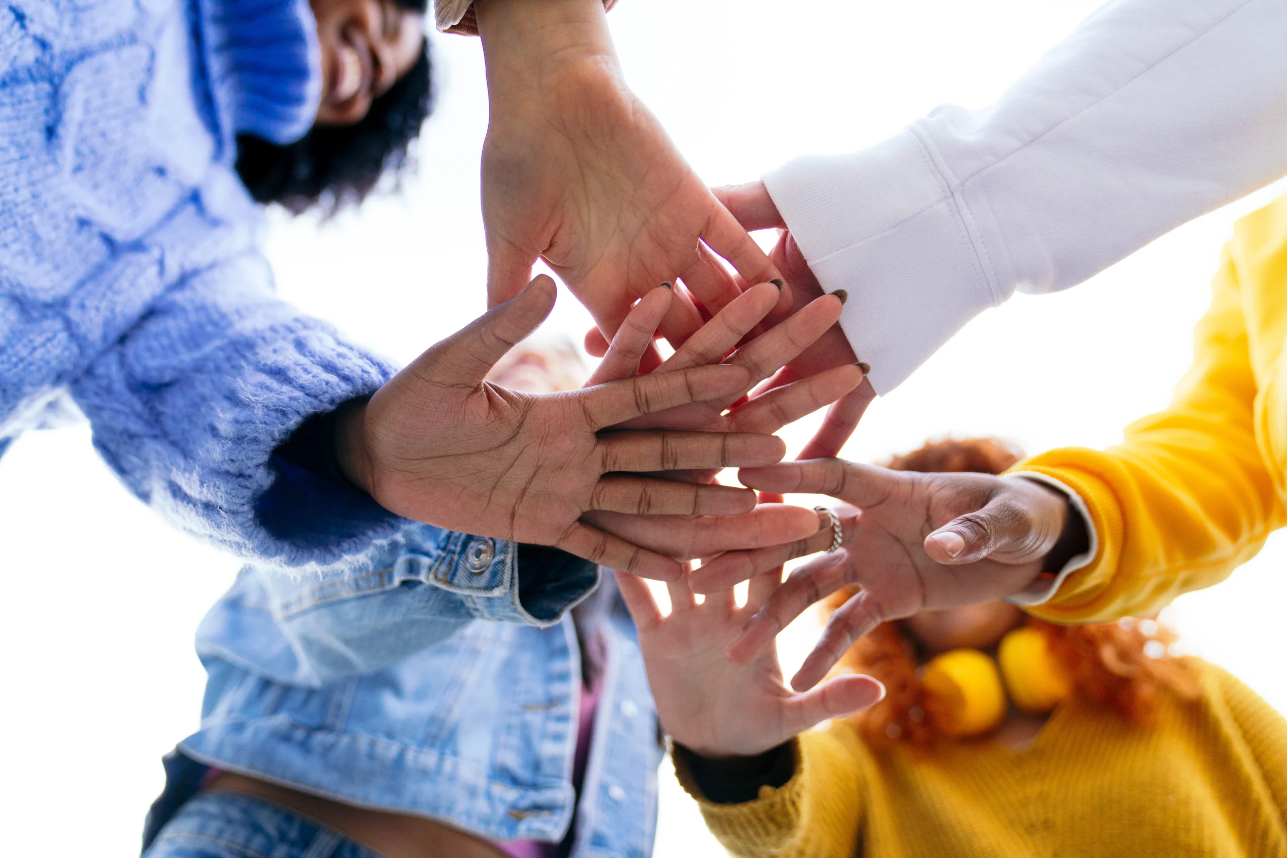 Team members stacking hands during a communication-based team building session in Malaysia