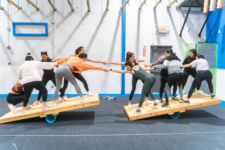 Team members completing an indoor obstacle course challenge for team building